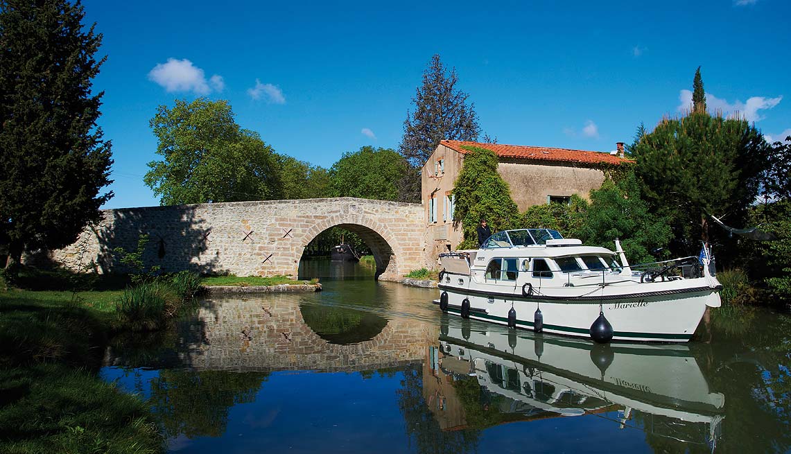 Een prachtige tocht over het met platanen omzoomde Canal du Midi Een prachtige tocht over het met platanen omzoomde Canal du Midi
